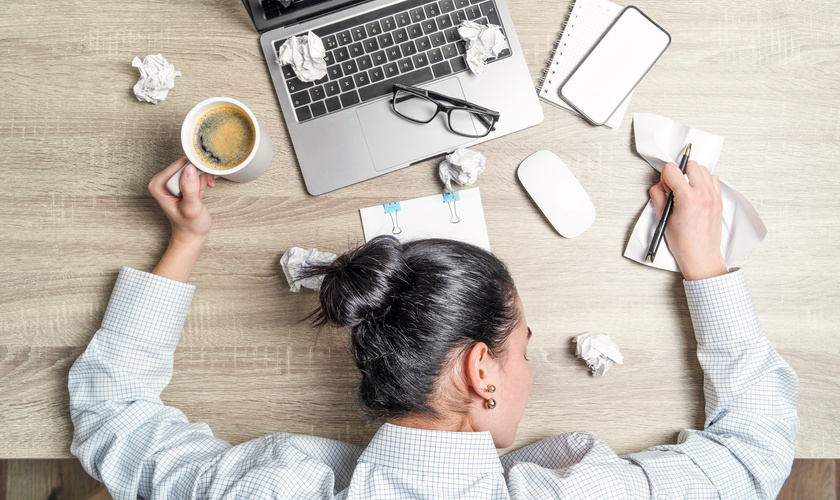 Tired Worker Sleeping on Messy Work Desk 